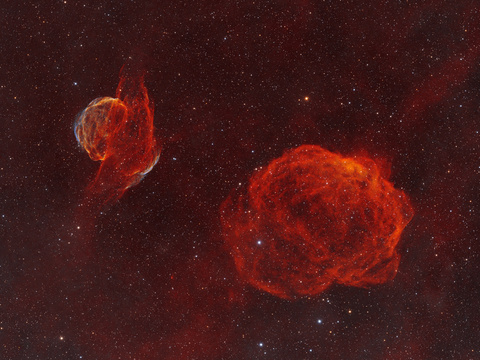 Rice Hat — Diese Weitfeld-Schmalbandaufnahme im Sternbild Auriga zeigt das extrem lichtschwache Sharpless-Paar Sh2-224 (der "Rice Hat"-Supernovaüberrest) und die benachbarte H-II-Region Sh2-223, die als feine rote Filamente vor einem dichten Sternfeld leuchten. Entstanden in Obercrinitz an vier Nächten mit dem Samyang 135 mm und der ASI533MM-PRO aus 70×600 s H-alpha- sowie 78×600 s OIII-Belichtungen.Autor: RobertLizenz: CC BY-NC-ND 4.0
